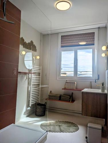 une salle de bain avec un lavabo et une fenêtre dans l'établissement Sylonie, à Châteauroux