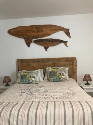 a bed with a wooden headboard with two fish on the wall at Budget Boutique in Blomtuin