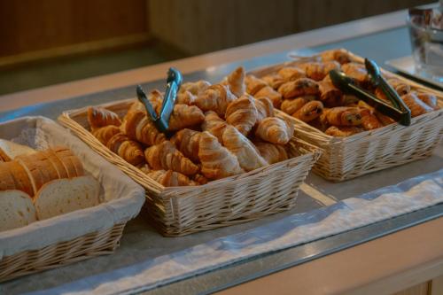 3 Körbe Brot und Gebäck auf der Theke in der Unterkunft Club Vacances Bleues Les Horizons du Lac (anciennement Serre-du-Villard) in Chorges