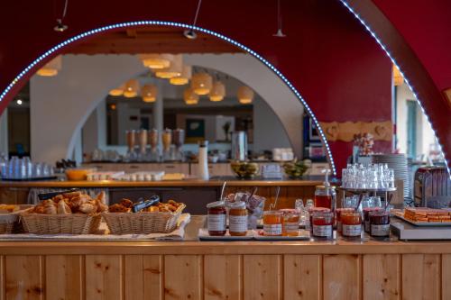 ein Restaurant mit einer Theke und Körben mit Lebensmitteln in der Unterkunft Club Vacances Bleues Les Horizons du Lac (anciennement Serre-du-Villard) in Chorges
