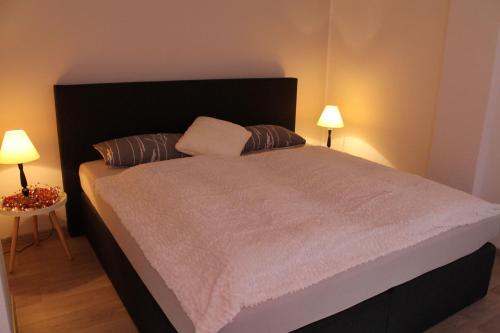 ein Schlafzimmer mit einem großen Bett mit zwei Lampen in der Unterkunft Ferien im Laden in Quedlinburg