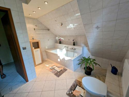 a bathroom with a tub and a toilet and a sink at Ferienwohnung Suchomski in Baabe