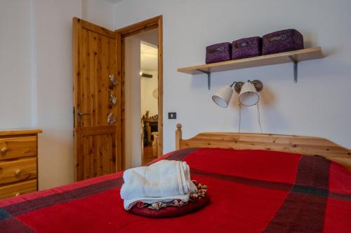 a bedroom with a wooden bed with a red bedspread and a wooden door at CasaLiri in Cappadocia