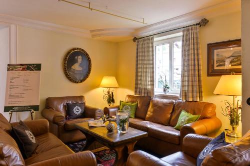 a living room with brown leather furniture and a window at Kertess in Sankt Anton am Arlberg