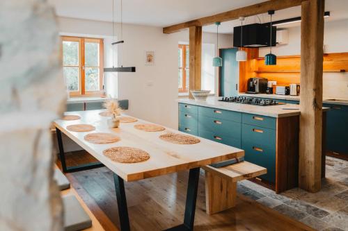 a kitchen with a wooden table and blue cabinets at Mountain Lodge Istria - Stone Lodge II in Roč