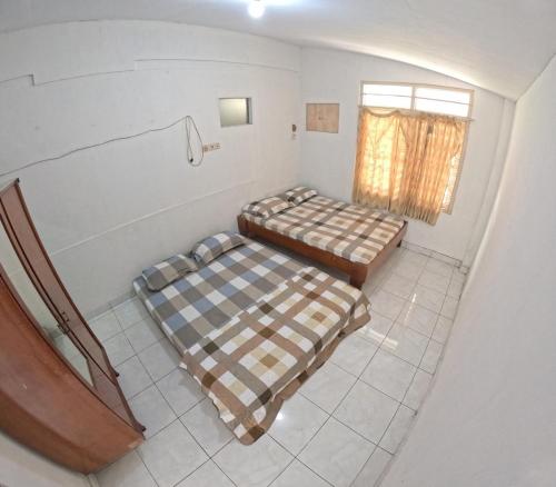 two beds in a room with a window at Fanda Homestay Malioboro in Sentool