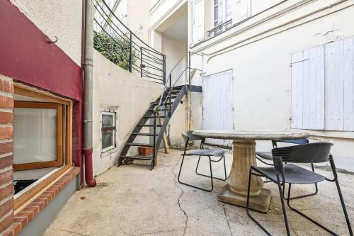 une pièce avec une table, des chaises et un escalier dans l'établissement Studio with Little Garden-Terrace at Trocadero, à Paris