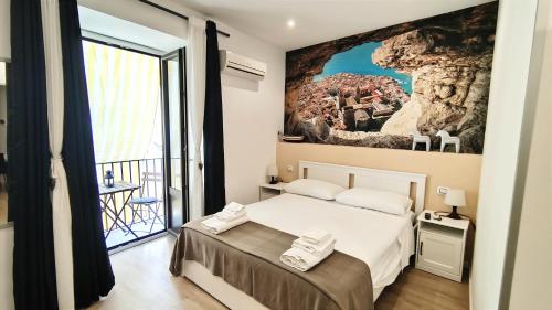 a bedroom with a bed and a large window at Antoinette Maison in Cefalù