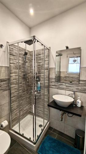 a bathroom with a glass shower and a sink at Antoinette Maison in Cefalù