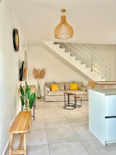 a living room with a couch and a table at Villa - Cosy - Piscine - Guadeloupe centre in Baie-Mahault