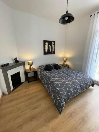 une chambre avec un lit et une cheminée dans l'établissement Bel appartement - Béziers - 4 pers - Balcon - Centre - IUT, à Béziers