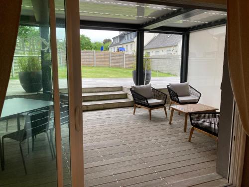 - une véranda avec 2 chaises et une table dans l'établissement Eden, à Saint-Martin-des-Champs