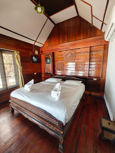 a bedroom with a bed in a room with wooden walls at Ziggy Stardust in Ko Phayam