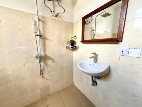 a bathroom with a sink and a shower at Stylish 2 Bedroom Apt - 1min walk to the Indian Ocean in Umbuji