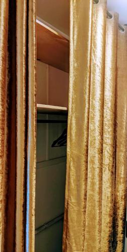 a gold curtain in a room with at Chambre Voltaire ou Chambre Beckett, terrasse en bord de Sorgue in Le Thor