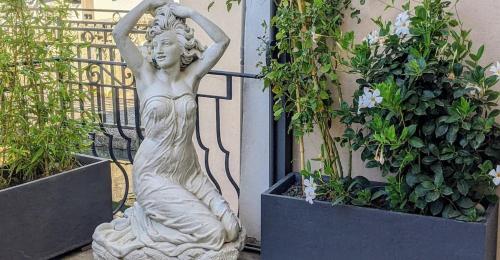 a statue of a woman standing next to some plants at Chambre Voltaire ou Chambre Beckett, terrasse en bord de Sorgue in Le Thor
