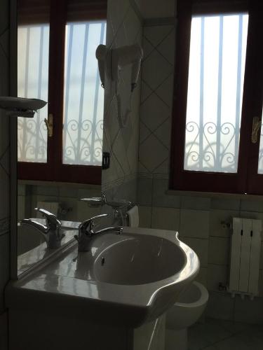 a bathroom with a sink and a toilet and a mirror at Holiday Home Gionny & Mary in Taormina