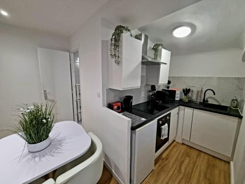 une cuisine avec des armoires blanches et une table à l'intérieur dans l'établissement Appart T2 Vieux port place Daviel, à Marseille