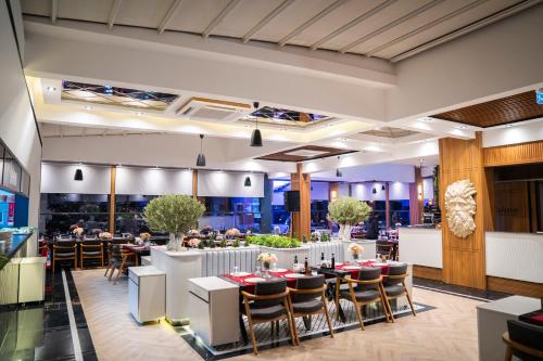 a dining room with tables and chairs and people eating at Leman Otel in Denizli