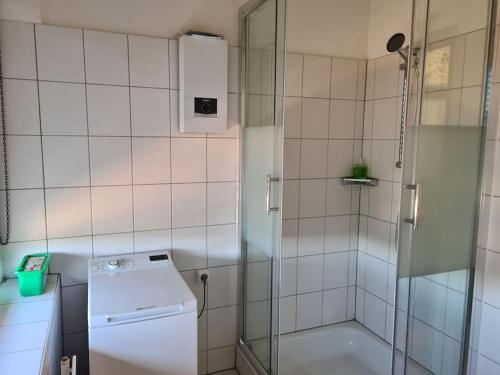 a bathroom with a shower and a washer at Schöne Eigentumswohnung Saarlouis in Saarlouis