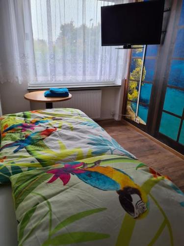 a bedroom with a bed with a colorful comforter at Schöne Eigentumswohnung Saarlouis in Saarlouis