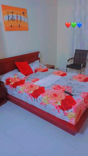 ein Bett mit roten Blumen darauf in einem Schlafzimmer in der Unterkunft bookingvilla in Yof