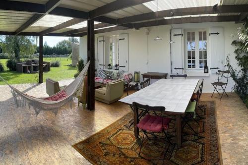 d'une terrasse avec un hamac, une table et des chaises. dans l'établissement Maison indépendante sur grand terrain clos, à Thénezay