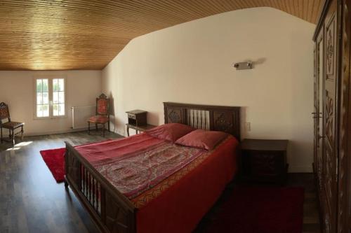 una camera da letto con un grande letto rosso in una stanza di Maison indépendante sur grand terrain clos a Thénezay