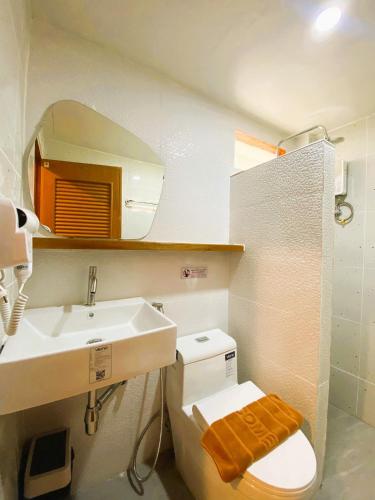 a bathroom with a sink and a toilet and a mirror at Ubox samui hostel & Bungalow - Chaweng beach in Chaweng