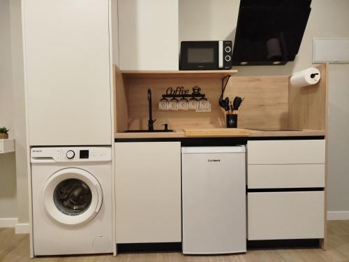 a kitchen with a washing machine and a washer and dryer at Ribera Home in Córdoba