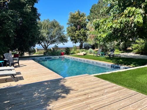 - une piscine dans une cour avec une terrasse en bois dans l'établissement Villa Saint Martin, à Malemort-du-Comtat