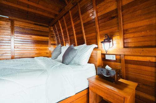 a bedroom with a bed in a wooden room at The Polumb Garden Bedugul in Tabanan