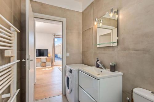 une salle de bain avec une machine à laver et un lavabo dans l'établissement Maison savorani, à Cap d'Ail