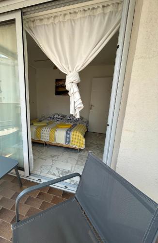 une terrasse couverte avec un lit à l'arrière d'une maison dans l'établissement Chambre confortable chez l'habitant, à Toulon