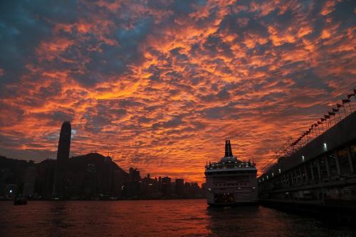 a cruise ship in the water with a sunset at Smiley Inn in Hong Kong