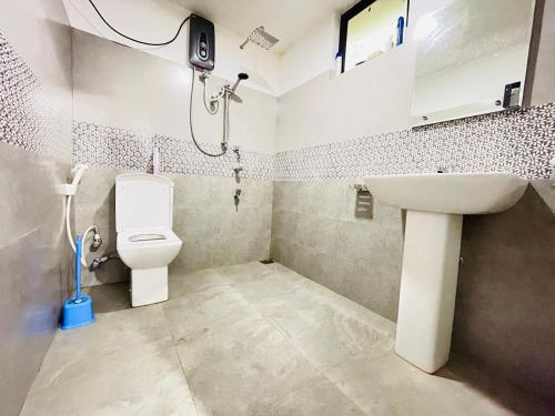 a bathroom with a toilet and a sink at The Villa in Massalapitiya