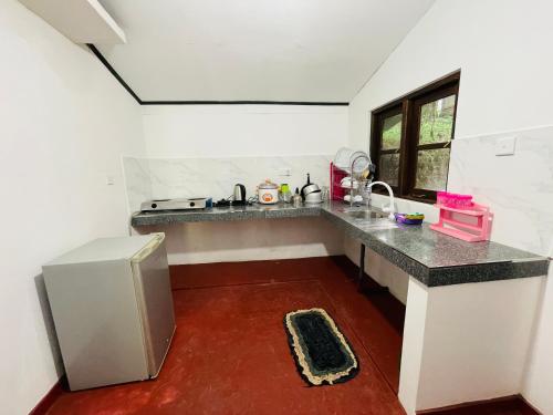 a kitchen with a counter and a refrigerator at The Villa in Massalapitiya