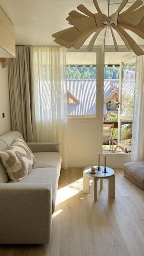 un salon avec un canapé et une table dans l'établissement Baby Jane, Studio front de neige, à Isola