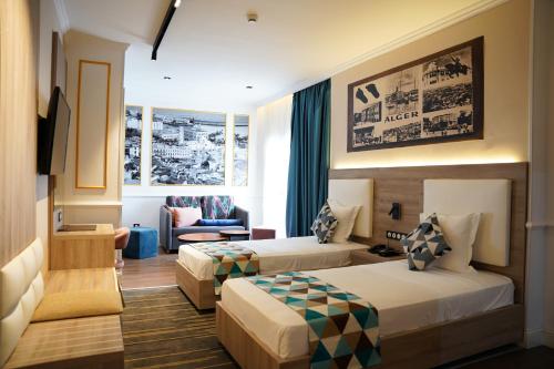a hotel room with two beds and a couch at Atlantis Alger in Alger