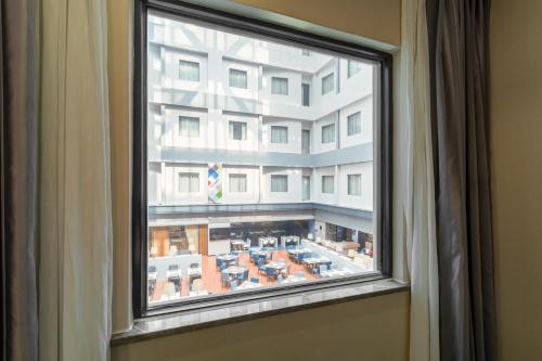 a window with a view of a building at Holiday Inn Express Shenyang North Station by IHG in Shenyang