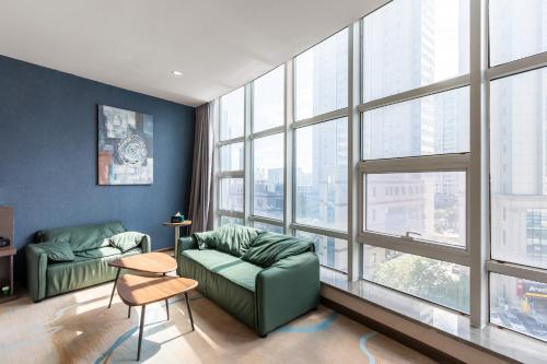 a living room with a green couch and a large window at Holiday Inn Express Shenyang North Station by IHG in Shenyang