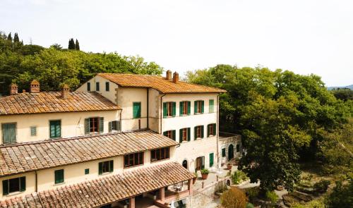 a group of buildings with tile roofs and trees at Hotel Villa Casalecchi in Castellina in Chianti