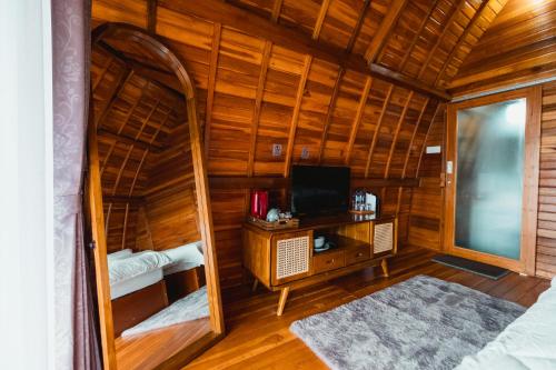 a room with a tv and a desk in a room at The Polumb Garden Bedugul in Tabanan