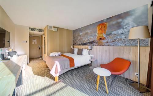 a hotel room with a bed and a red chair at Mercure Gdańsk Posejdon in Gdańsk