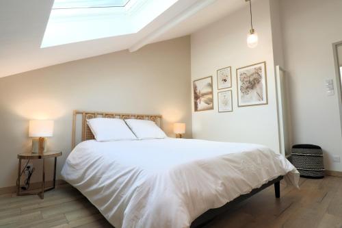 - une chambre avec un grand lit blanc et une lucarne dans l'établissement Superbe appartement 2 chambres proche Nancy Thermal, à Laxou