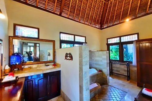 a bathroom with a sink and a mirror at Kavita 1 BR Grand Deluxe Valley View ZN236 in Ubud