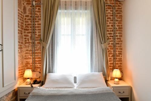 a bedroom with a bed in front of a window at Cunda Ömer Ağa Konağı in Cunda