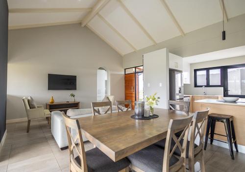 a dining room and kitchen with a wooden table and chairs at Hotel Olivewood in East London