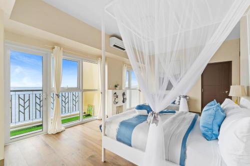 a bedroom with a bed and a large window at Luxury Condo Ocean View 1,2,3, & 4 Bedrooms Infinity Pool Gym Spa Next to Okada Solaire MOA NAIA Airport in Manila