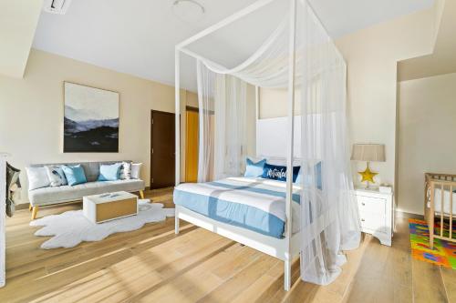 a bedroom with a canopy bed and a crib at Luxury Condo Ocean View 1,2,3, & 4 Bedrooms Infinity Pool Gym Spa Next to Okada Solaire MOA NAIA Airport in Manila